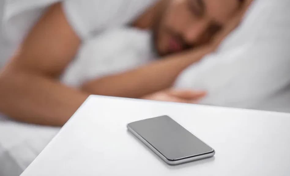 Téléphone sur la table de nuit - premier réflexe de la journée